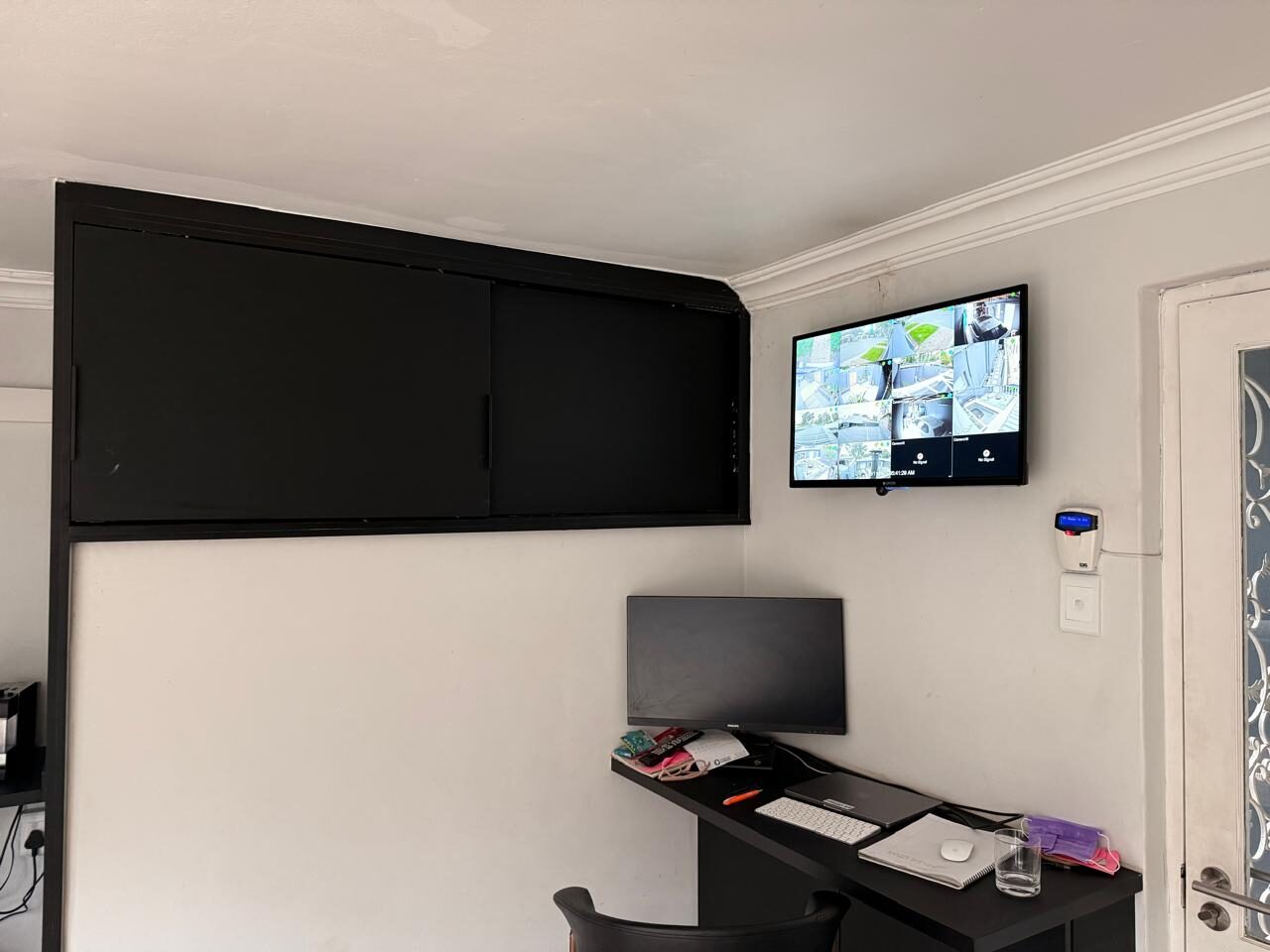 Wall-mounted CCTV monitor showing a live multi-camera feed after installation